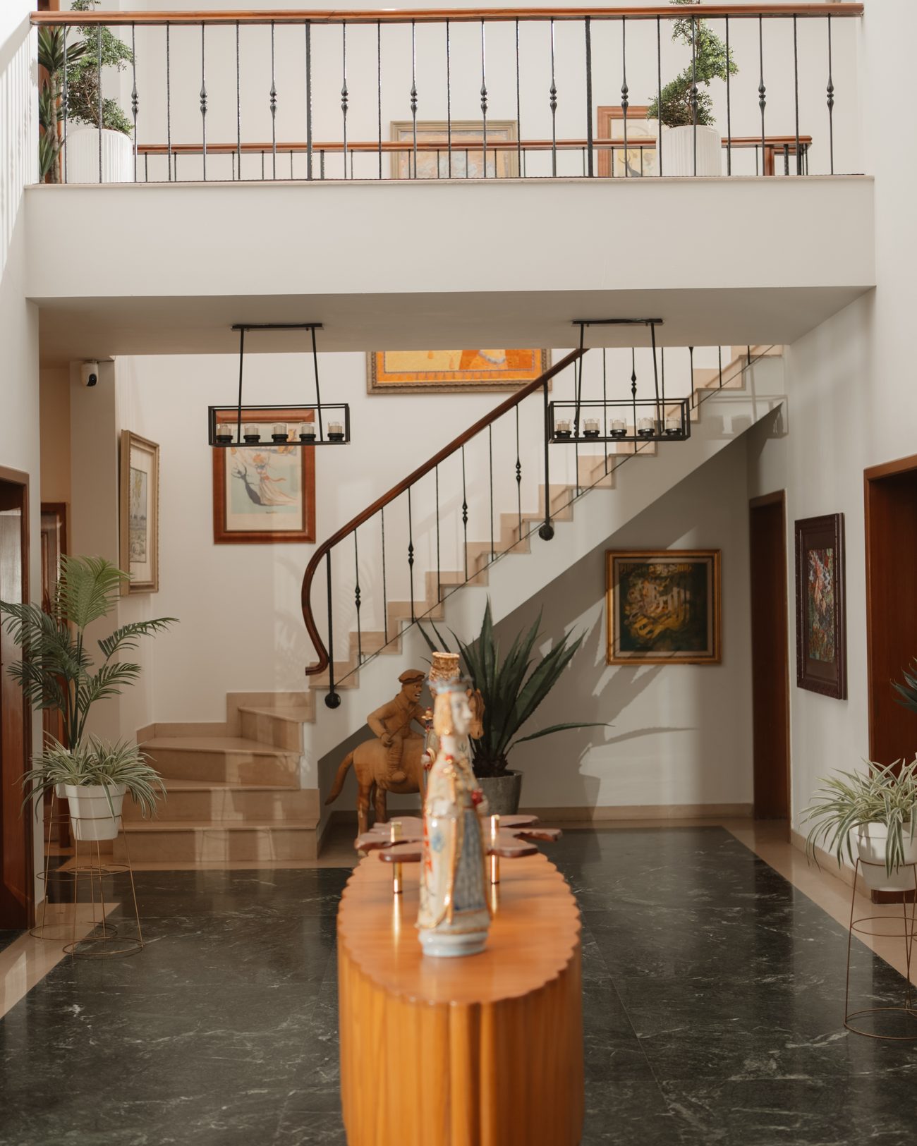 Double-height hall with a curved staircase and a fluted timber console