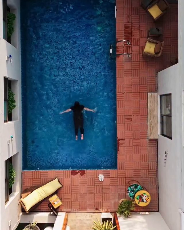 A pool seen from above beside a terracotta terrace
