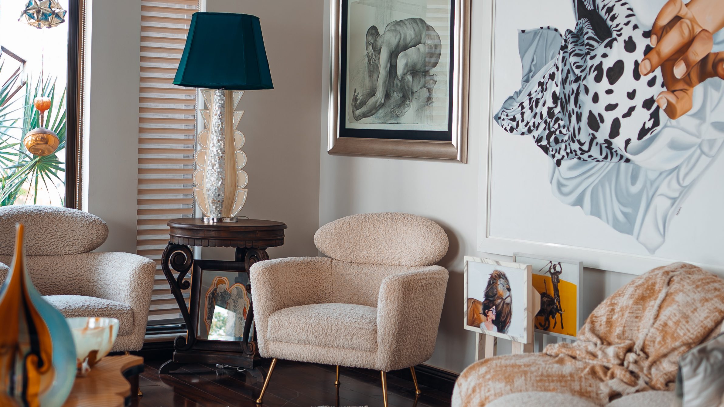Bouclé armchair, a green lamp and a framed charcoal drawing in a pale lounge