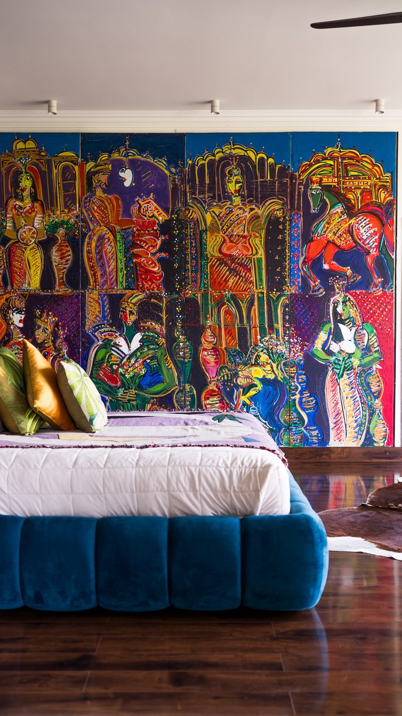 Bedroom built around a four-panel painted mural and a deep blue velvet bed