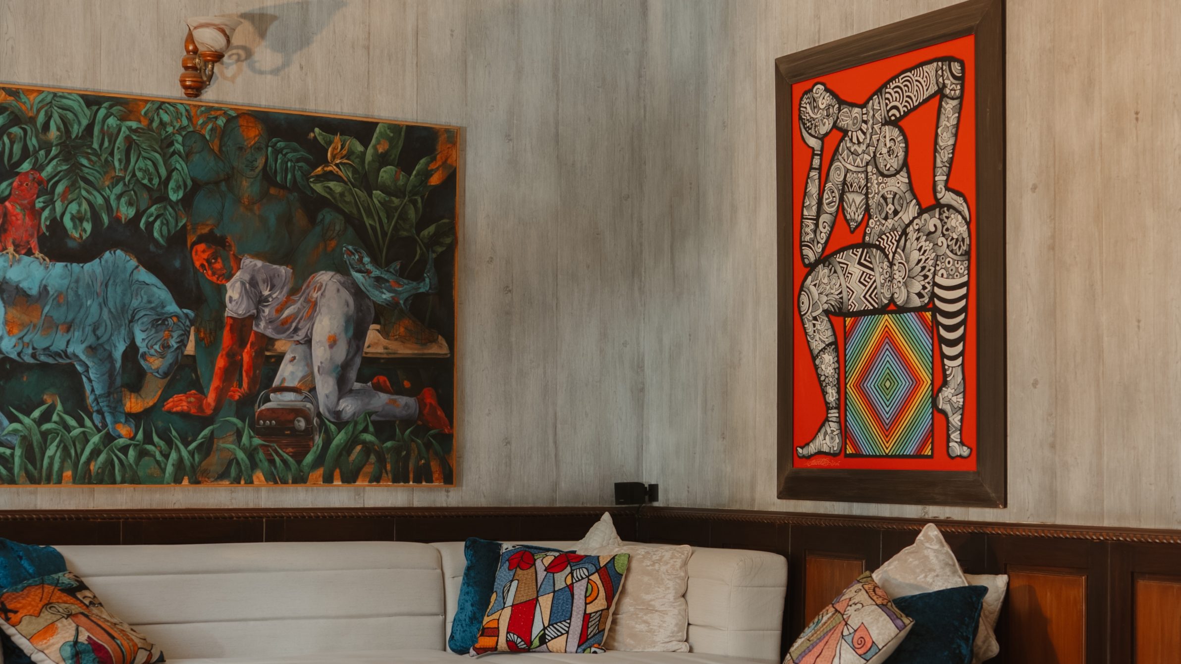 White sectional sofa beneath two large paintings