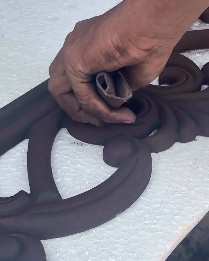 A carved frame being shaped by hand in the workshop