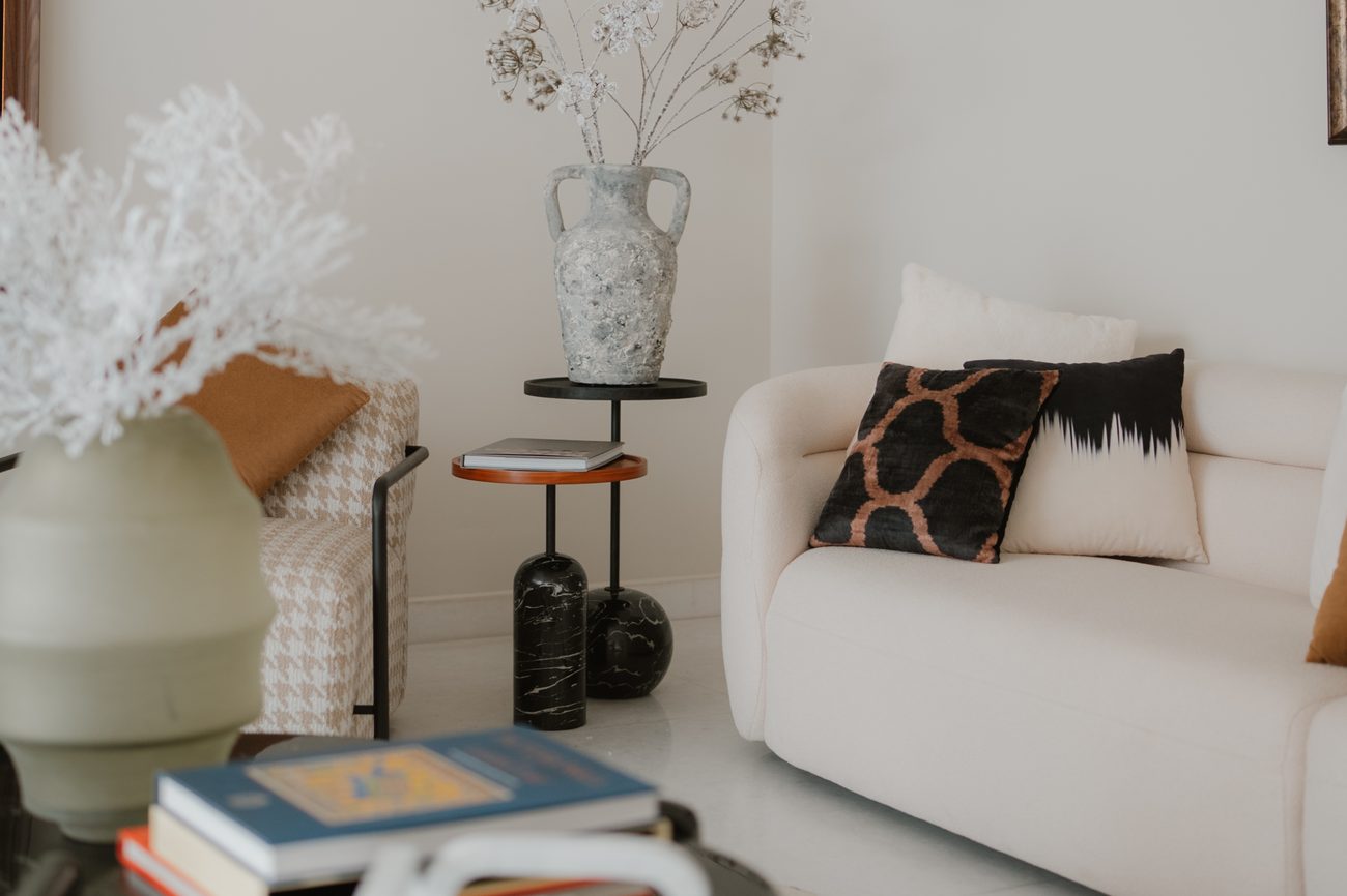 Marble table with a chain sculpture and a vase of white coral in a styled lounge